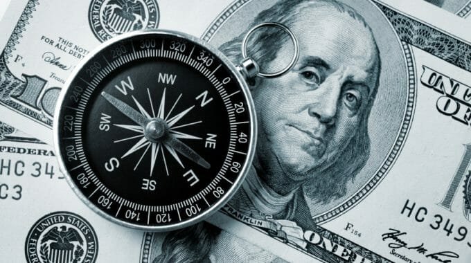 Compass on hundred dollar background